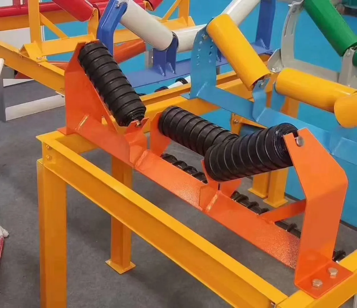Rubber-ring impact idler set on a yellow support frame