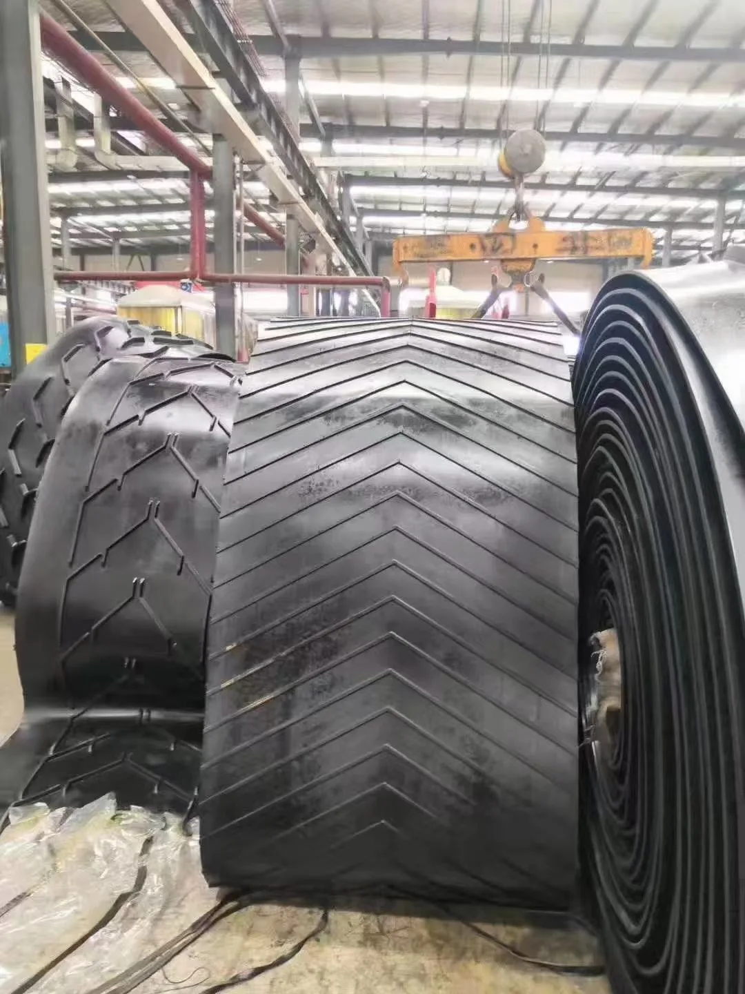 Rolls of chevron-pattern conveyor belting in a workshop