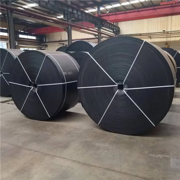 Conveyor belt rolls secured with straps in a workshop